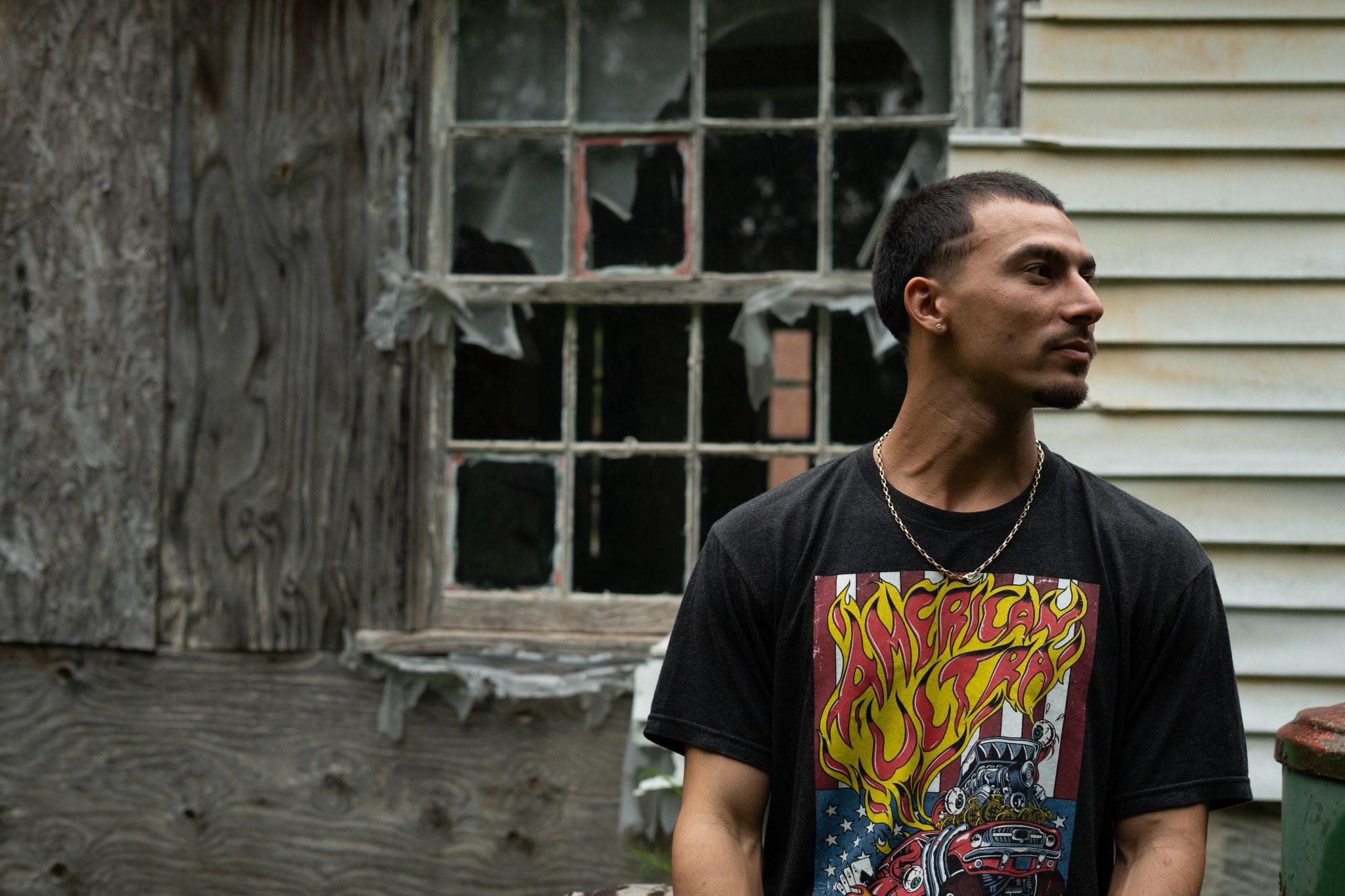Environmental portrait by Andrew Frady beside a weathered building