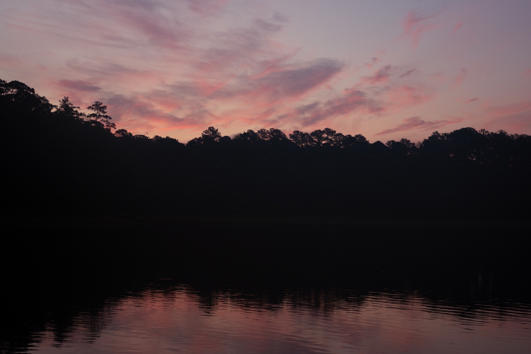 Sunrise reflected on a quiet lake, photographed by Andrew Frady